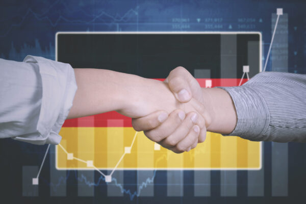 Hands of business team shaking hands, growth chart with German flag in the background